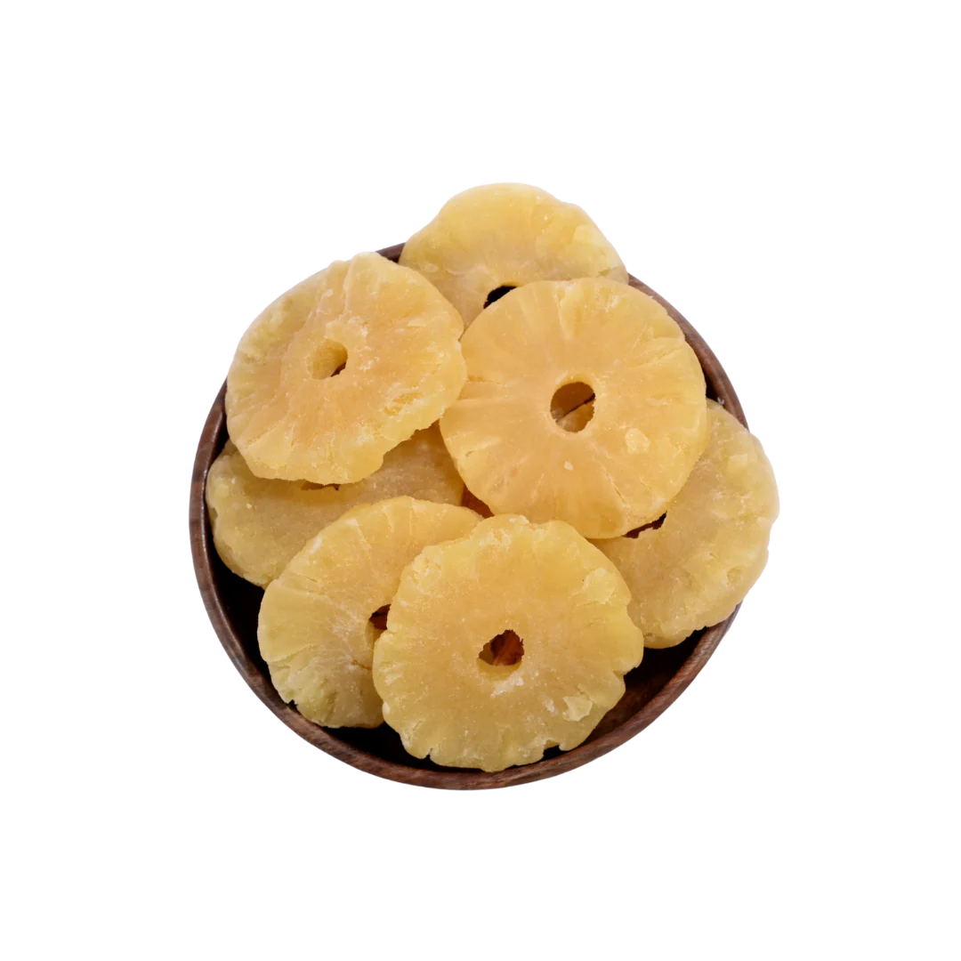 Dried pineapple rings in a wooden bowl on a white background