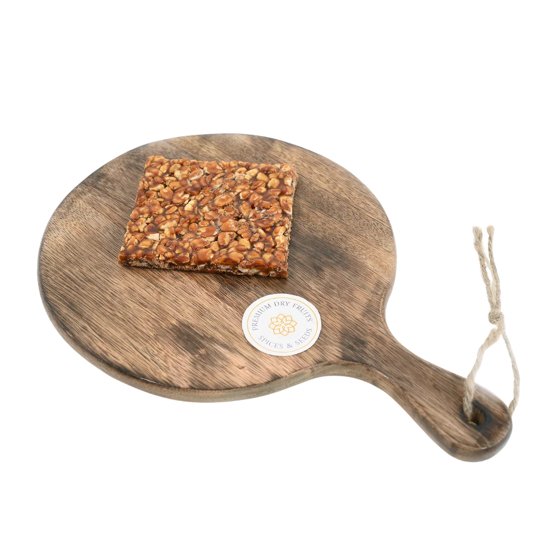 Peanut Chikki on wooden plate delicious Indian jaggery brittle loaded with peanuts tasty crunchy snack ideal for