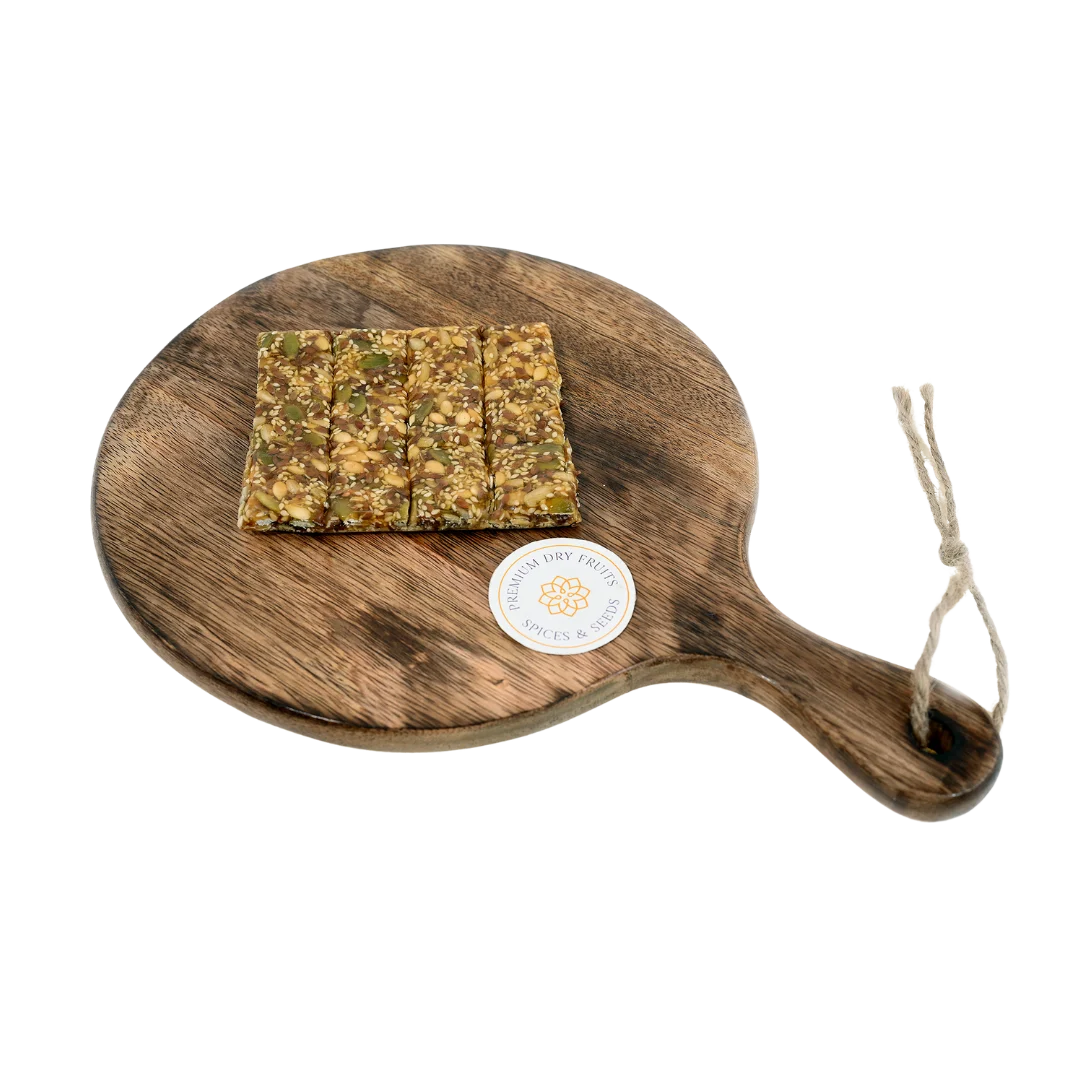 Seed Chikki on wooden plate traditional Indian sweet made with jaggery and mixed roasted seeds healthy crunchy snack perfect for winter and festive season