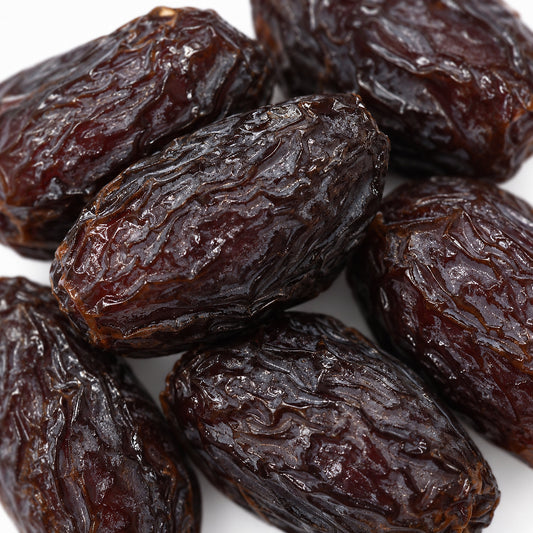 Close-up of Medjool dates, deep dark brown with soft wrinkled skin