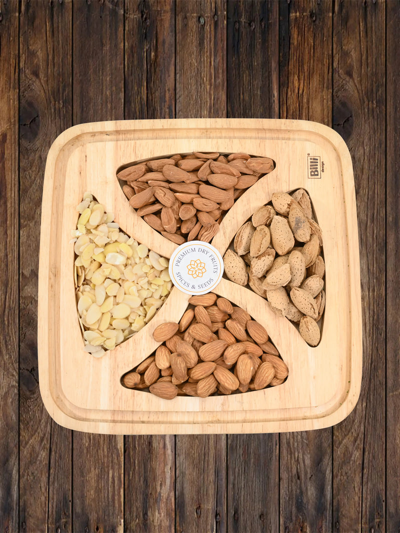 Wooden gift tray containing four sections of almonds – sliced almonds, whole almonds, and almonds in paper shell – placed on a rustic wooden background.