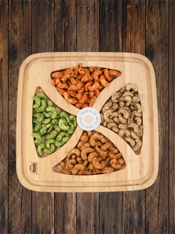 Assorted spiced cashews in wooden tray with peri peri, oregano, and green chilli flavors by House of Rasda