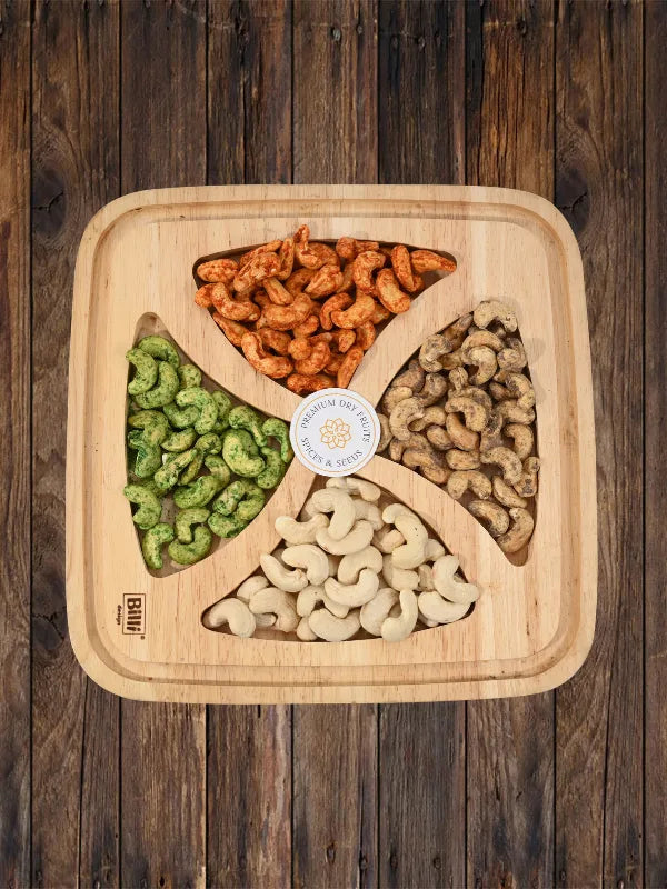 Assorted cashew nuts on wooden tray with plain, pepper, peri peri and green chilli flavors by House of Rasda.