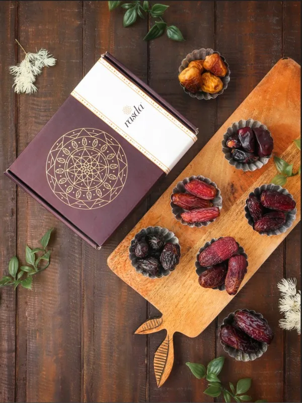 Assorted premium dates in metal cups on wooden board with luxury gift box  and all varieties of Dates