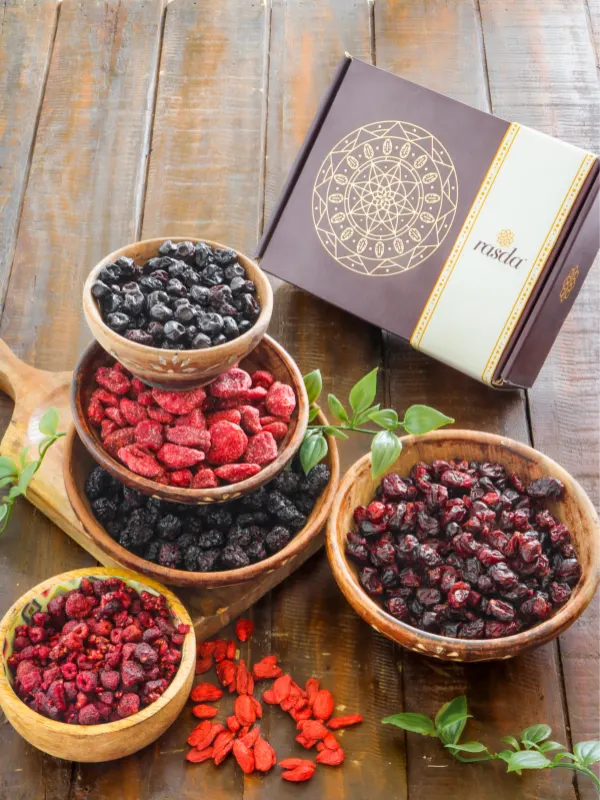 Assorted dried berries including blueberries, cranberries, goji and strawberries in wooden bowls with premium gift box by House of Rasda.