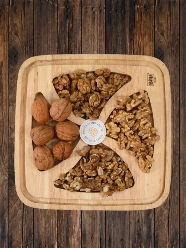 Premium walnut gift tray with Kashmiri akhrot kernels and whole walnuts on wooden board by House of Rasda.