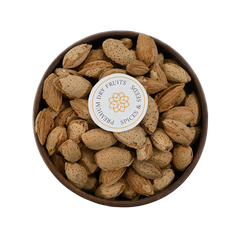 Natural in-shell almonds arranged in a simple wooden bowl, emphasizing freshness and authenticity.