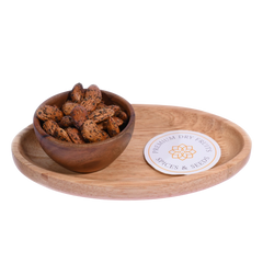 Wooden bowl with Almonds Pepper Spiced on a wooden tray with a label, on a white background 