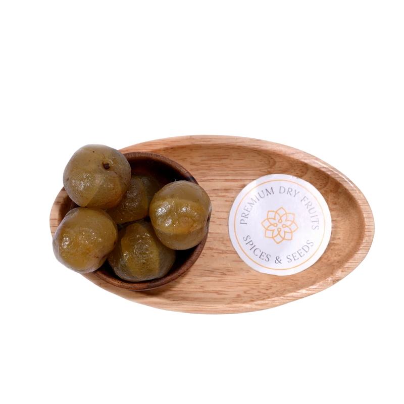 Top view of Amla Honey Dried pieces in a small wooden bowl on a rustic surface.