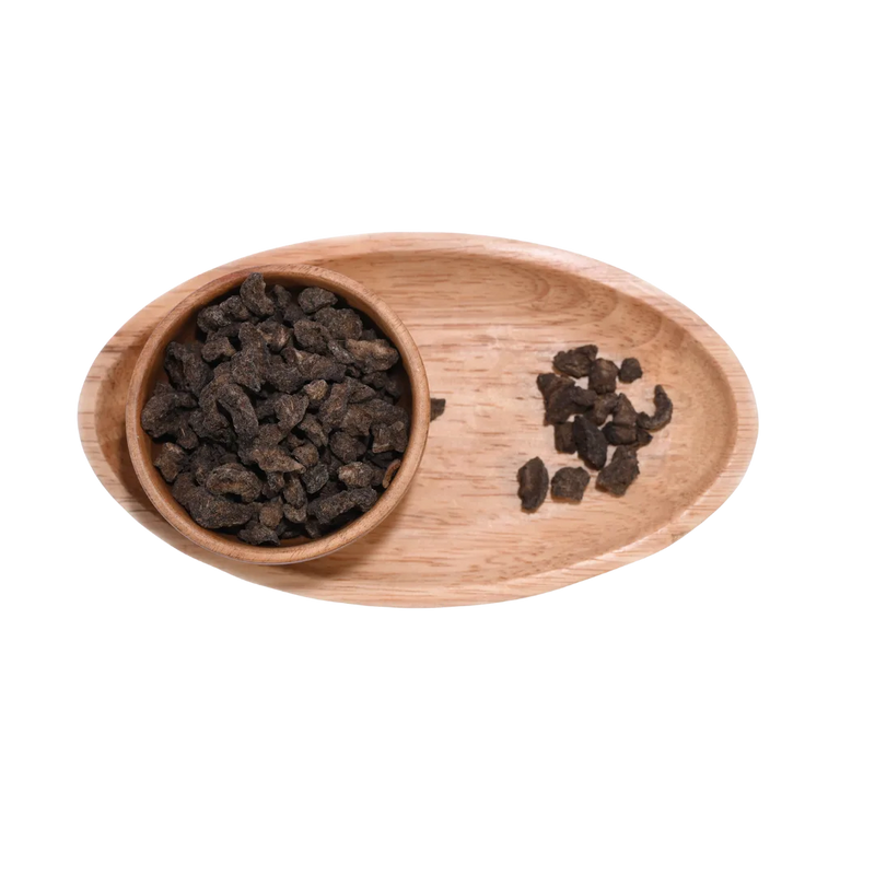 Top view of Amla Salted Dried pieces in a wooden bowl on a natural surface