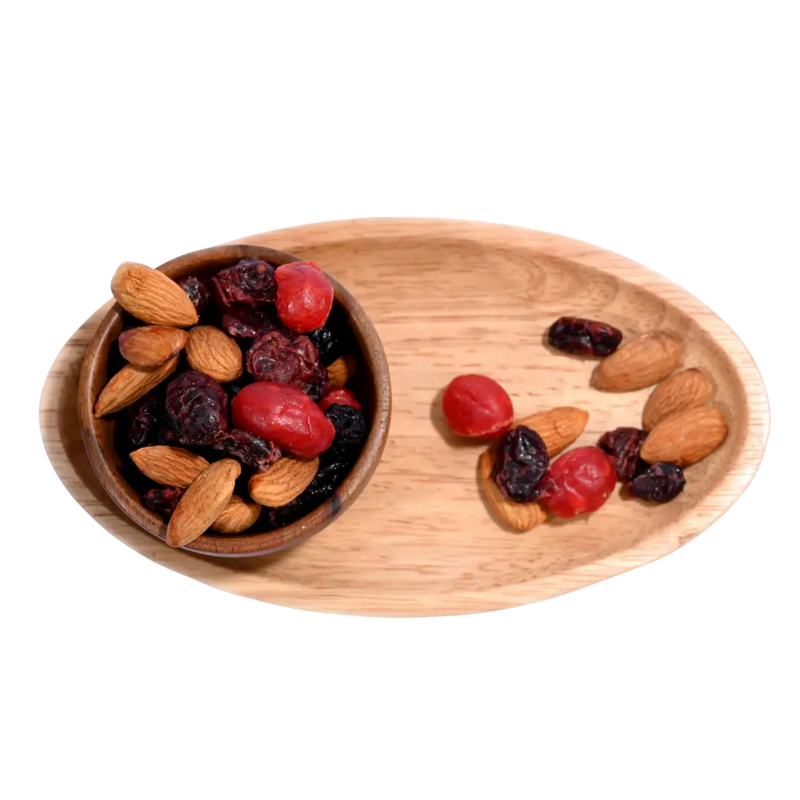 Antioxidant Trail Mix Wooden bowl and tray with almonds and dried fruits on a white background
