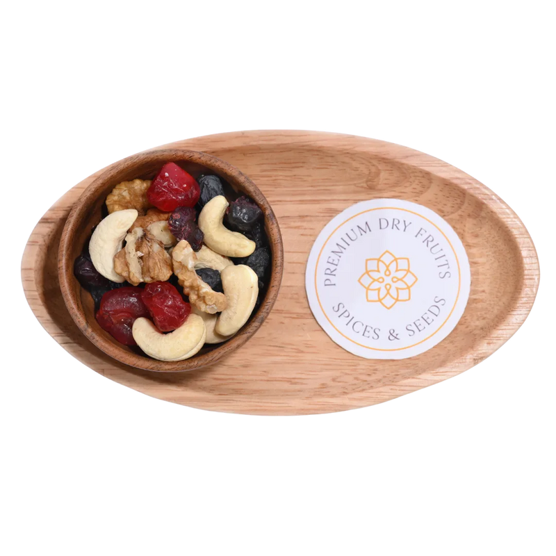 Wooden bowl with a mix of nuts and dried fruits on a white background, featuring a Berry Nutty Trail Mix