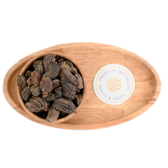 Close-up of whole black cardamom pods, showcasing their wrinkled, dark brown exterior with woody textures