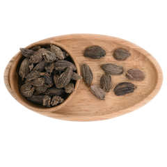 Dried black cardamom pods arranged on a rustic wooden surface, highlighting their smoky, bold flavor