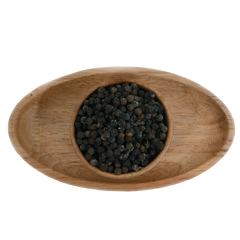 Whole black pepper corns scattered on a wooden Bowl