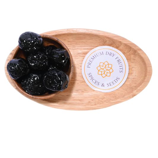 Close-up view of Black Plums Dehydrated arranged in a round wooden bowl.