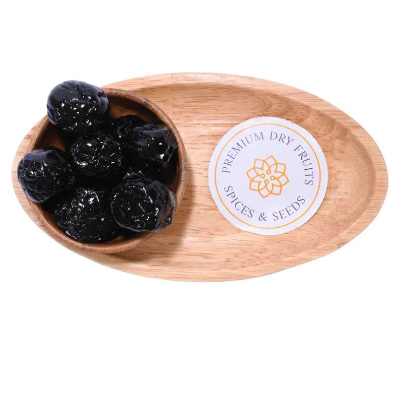 Close-up view of Black Plums Dehydrated arranged in a round wooden bowl.