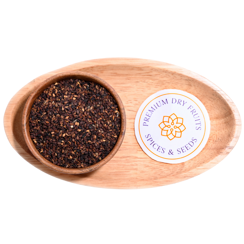 Close-up of small, black sesame seeds, scattered across a surface.