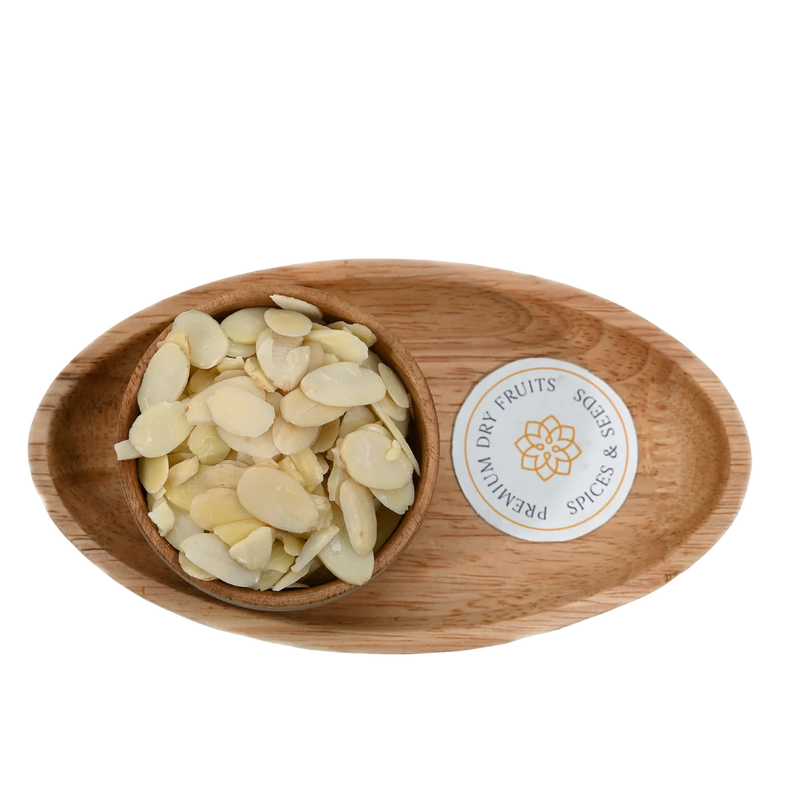 Crunchy Blanched Sliced Almonds Badam on wooden surface – natural gluten free almond flakes for desserts and baking recipes