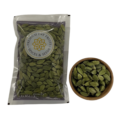 Packaged cardamom seeds with a bowl of cardamom seeds on a white background