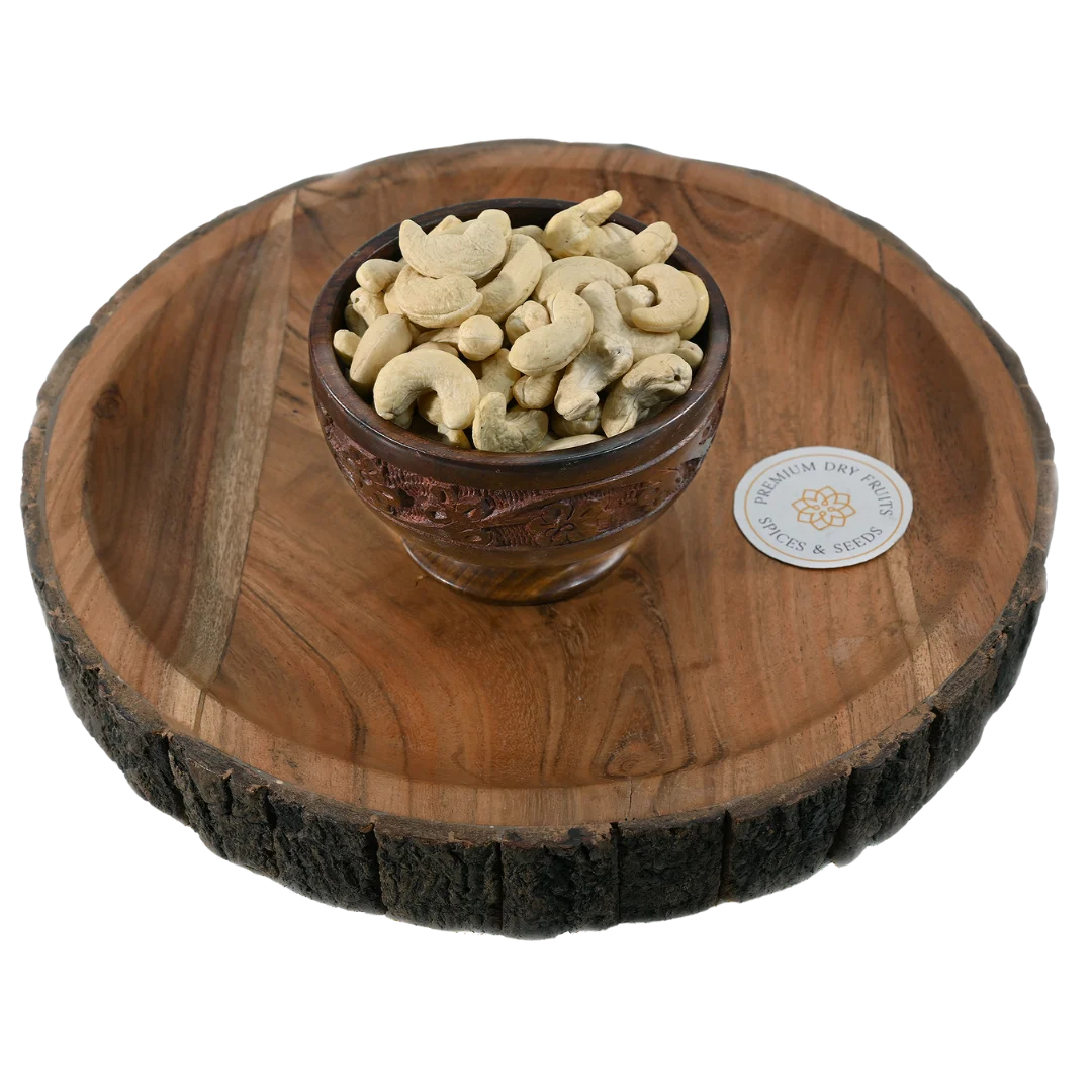 Fresh cashew nuts with smooth texture and natural cream colour, served in a wooden bowl, ideal for snacking and cooking, available to buy online from House of Rasda in Bangalore.