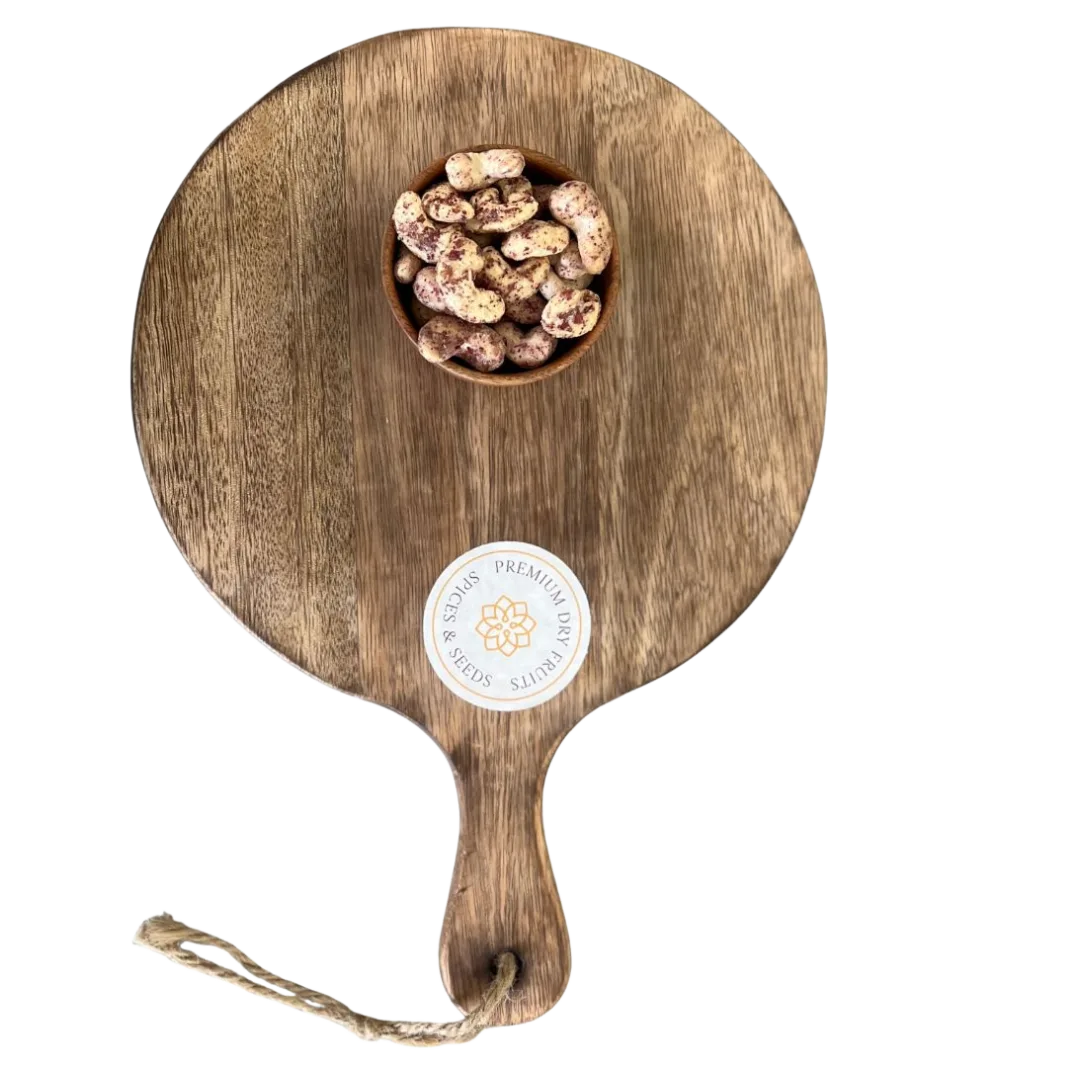 Wooden serving board with a handle and a small bowl of Cashew Nuts Rose Petal on a white background