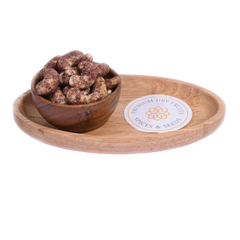 Wooden bowl with dried fruits(Cashew Nuts Rose Petal) on a wooden tray with a visible brand label.