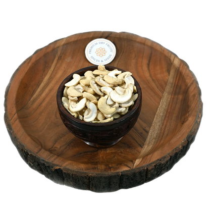 Split cashew kernels in wooden bowl - premium broken cashews for sweets and snacks