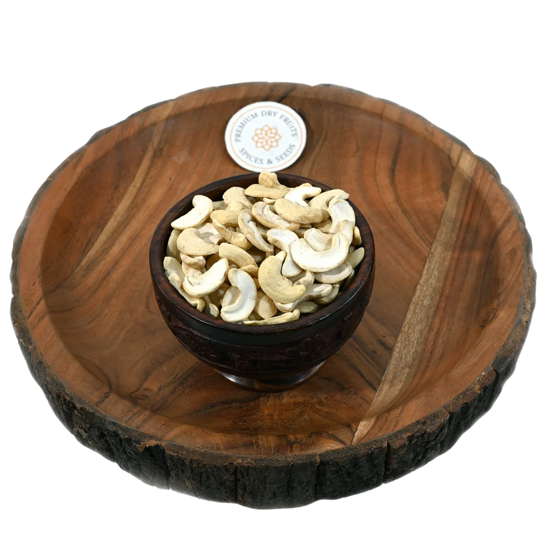 Fresh split cashew kernels displayed in a wooden bowl, buy premium cashews online in Bangalore from House of Rasda, perfect for sweets and snacks.