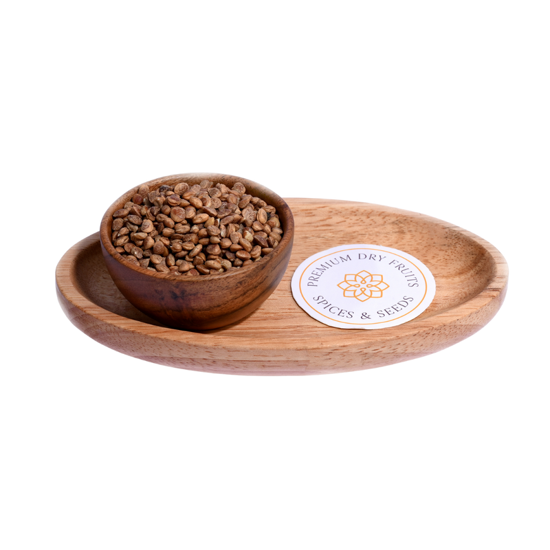 Close-up of charoli seeds, small, light brown, and oval-shaped. A bowl filled with charoli seeds, showing their light brown color and oval shape