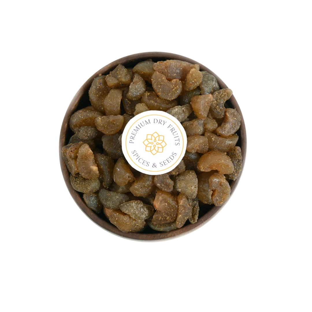 Close-up of Chatpata Amla Dried Candy pieces in a round wooden bowl.