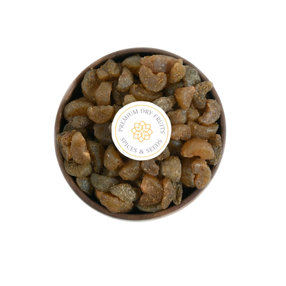 Close-up of Chatpata Amla Dried Candy pieces in a round wooden bowl.