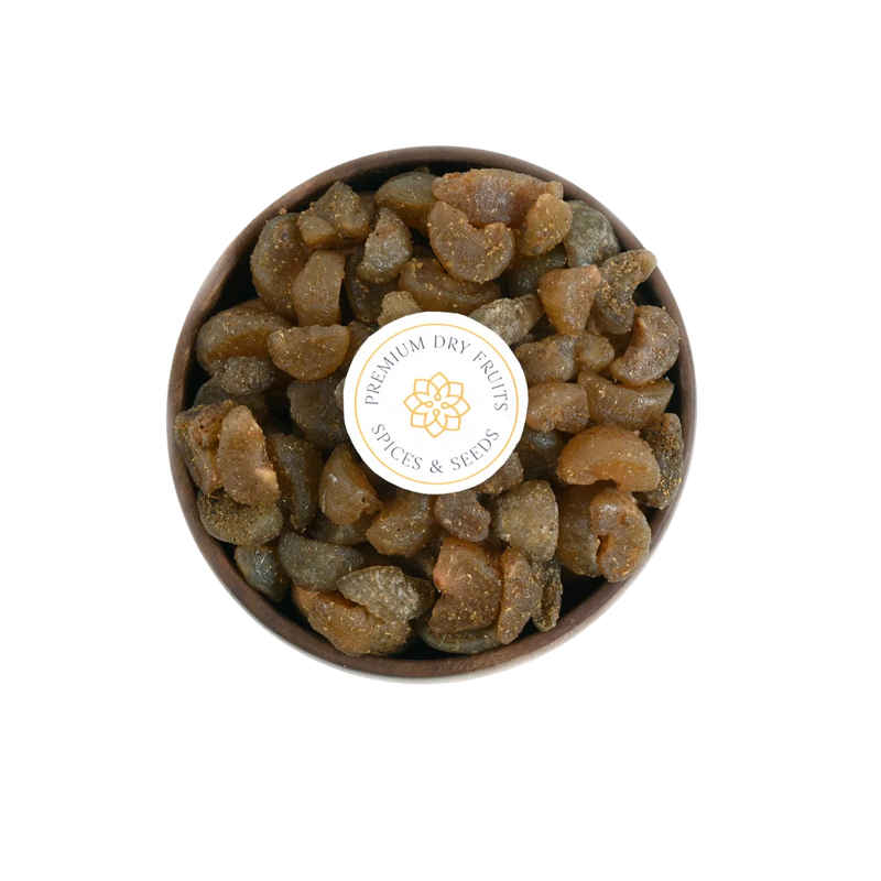 Close-up of Chatpata Amla Dried Candy pieces in a round wooden bowl.