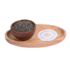 Wooden bowl with chia seeds on a wooden tray with a label, on a white background