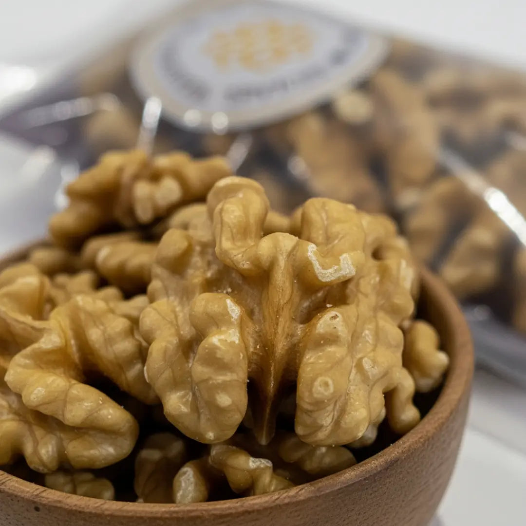 Close-up of premium Chilean walnut halves (Akhrot) in a wooden bowl showing fresh texture and quality.