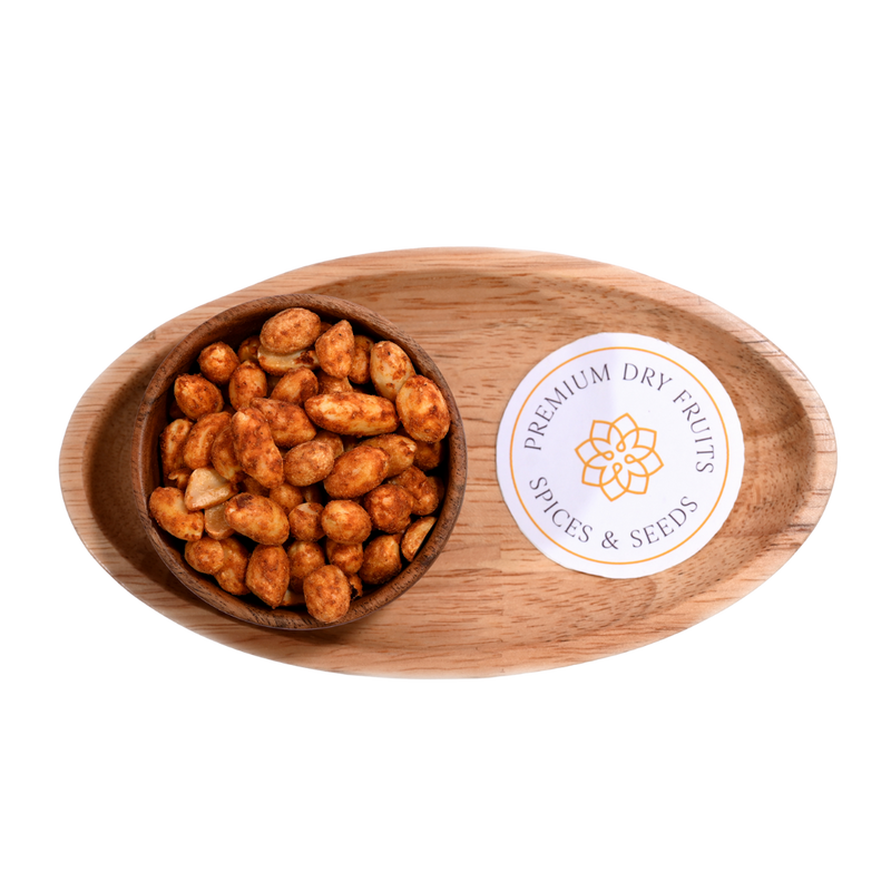 An overhead view of a colorful spread of chilli garlic peanuts, highlighting the red and gold hues of the spices used.