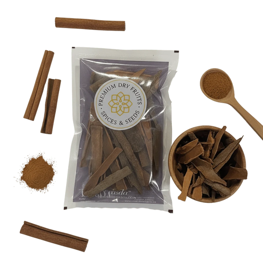 Cinnamon sticks with packaging and a wooden spoon on a white background