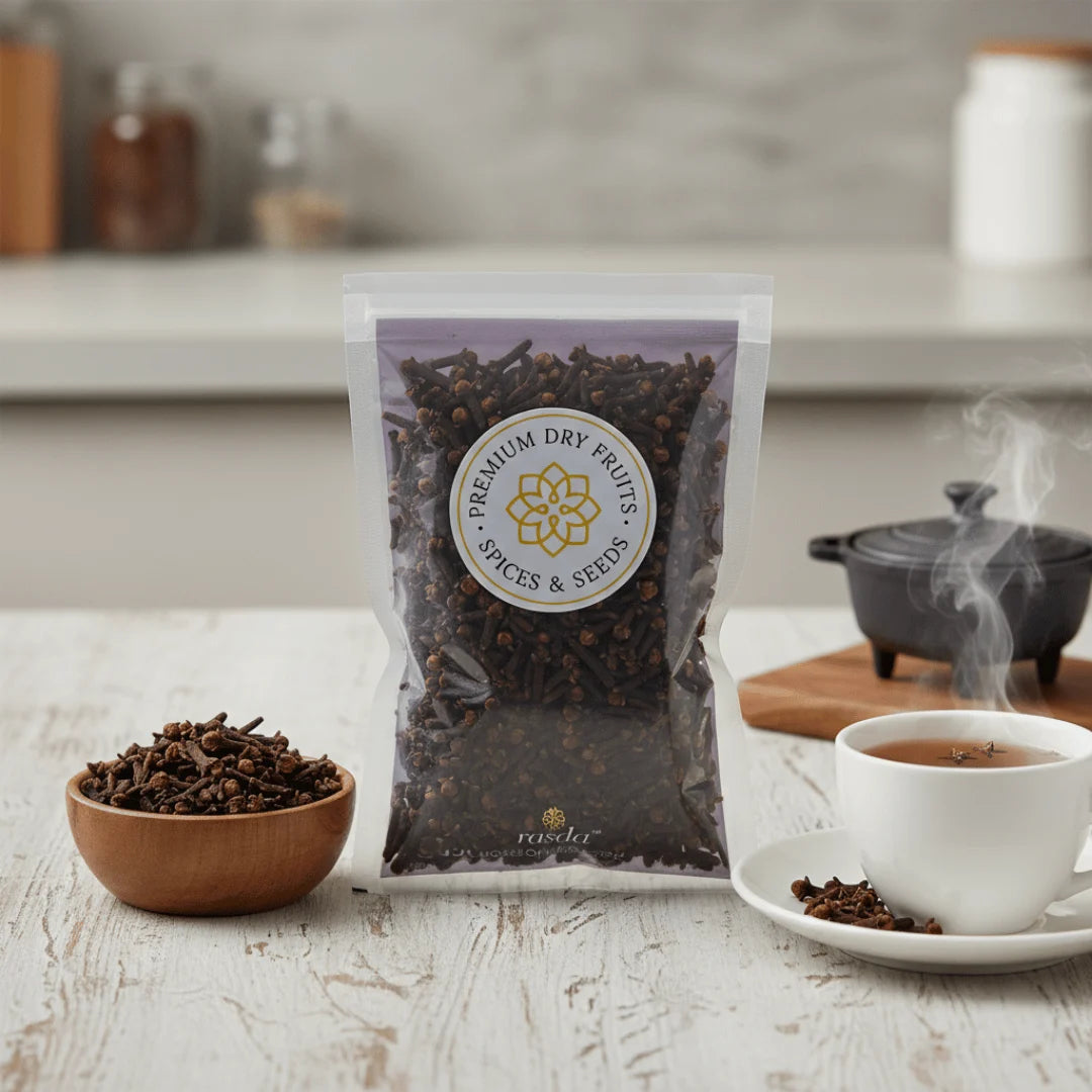 Premium whole cloves packed by Rasda with cloves in a wooden bowl and tea cup on wooden background