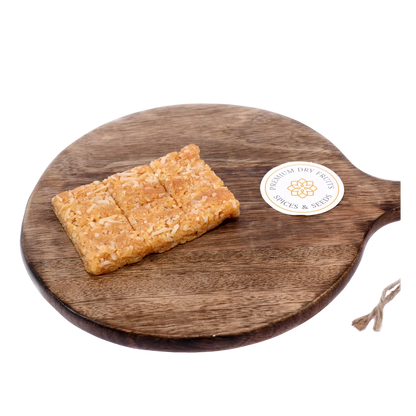 Coconut Chikki on wooden plate delicious Indian jaggery brittle with roasted coconut tasty crunchy snack ideal for