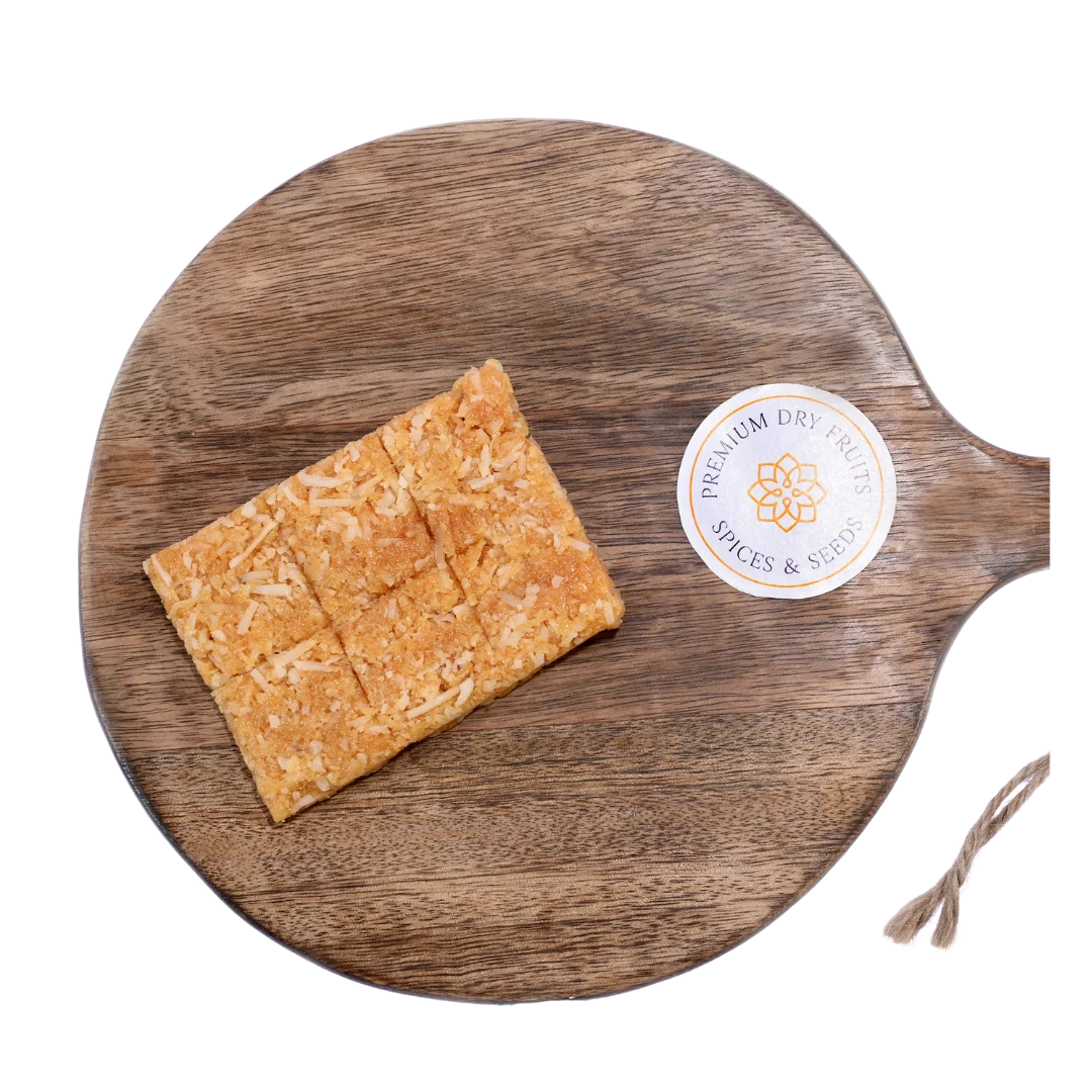 Coconut Chikki on wooden plate traditional Indian sweet made with grated coconut and jaggery healthy crunchy snack