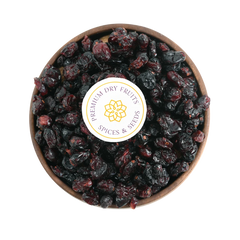 Close-up of glossy dried cranberries arranged in a rustic wooden bowl, highlighting their freshness and shine.