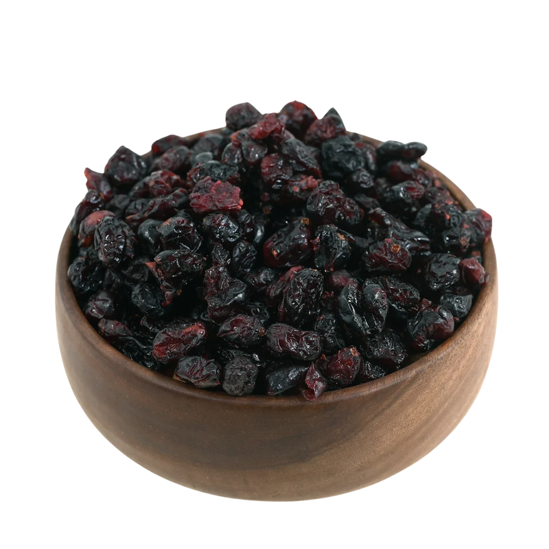 Natural whole dried cranberries beautifully presented in a handcrafted wooden bowl on a neutral background.
