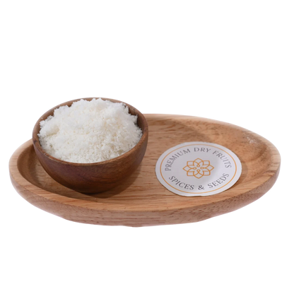 Fine white Desiccated Coconut Powder Nariyal Burada in a wooden bowl, showcasing its soft and fluffy texture.