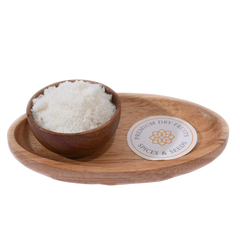 Fine white Desiccated Coconut Powder Nariyal Burada in a wooden bowl, showcasing its soft and fluffy texture.
