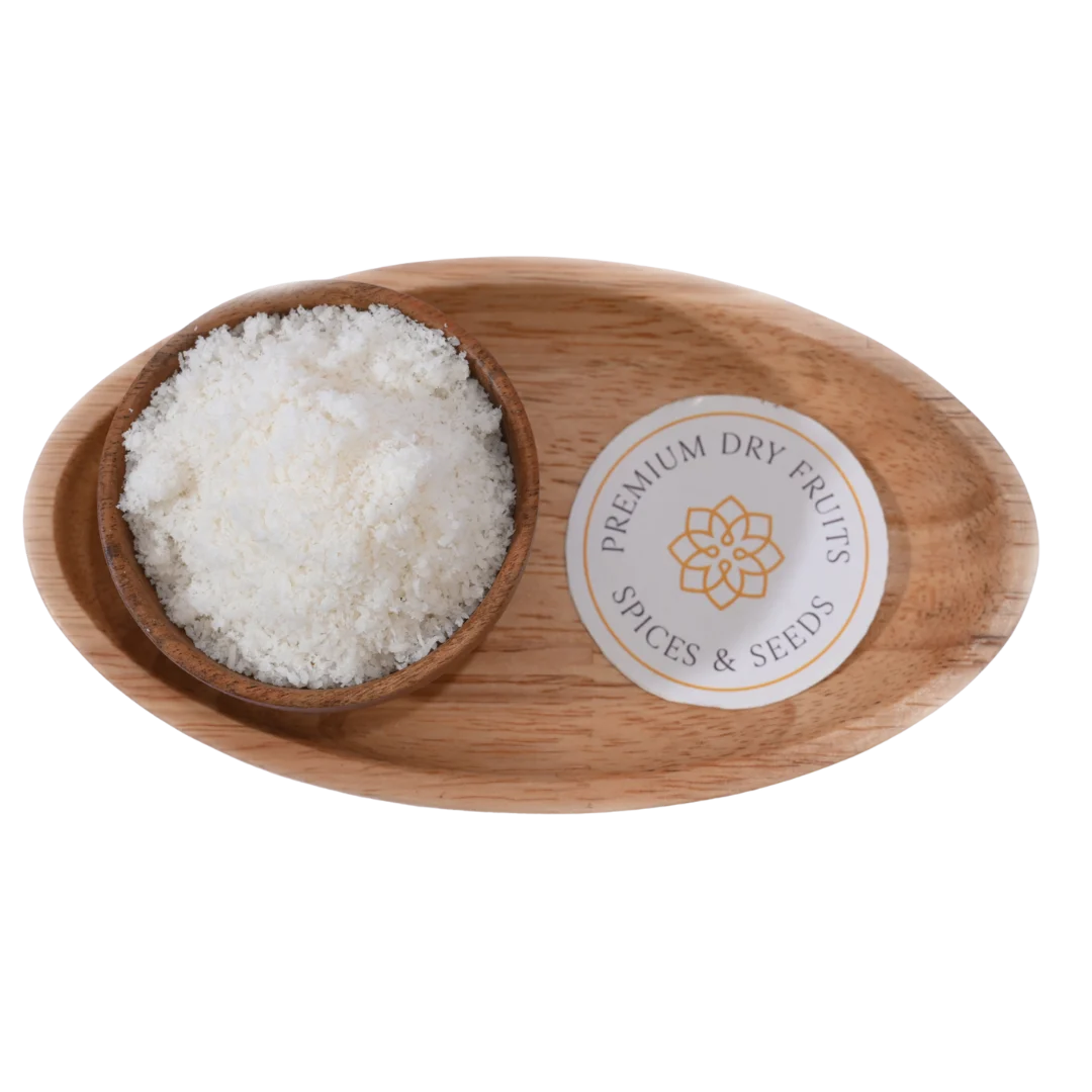 Fine white Desiccated Coconut Powder Nariyal Burada in a wooden bowl, showcasing its soft and fluffy texture.