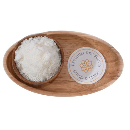 Fine white Desiccated Coconut Powder Nariyal Burada in a wooden bowl, showcasing its soft and fluffy texture.