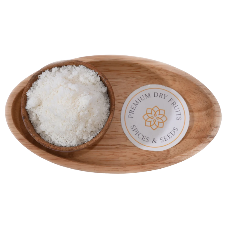 Fine white Desiccated Coconut Powder Nariyal Burada in a wooden bowl, showcasing its soft and fluffy texture.