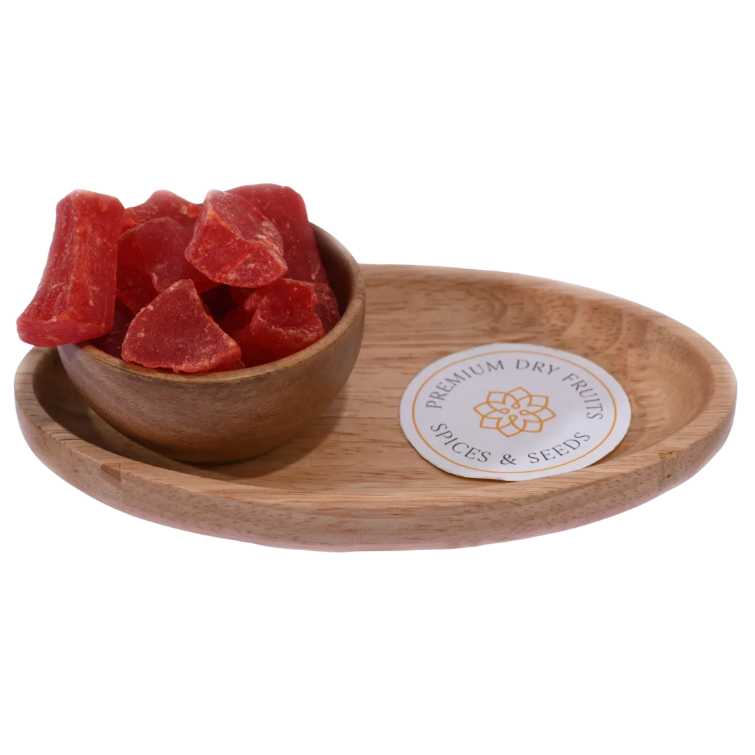 Dried papaya cubes spilling slightly from a wooden bowl, with a soft-focus background.