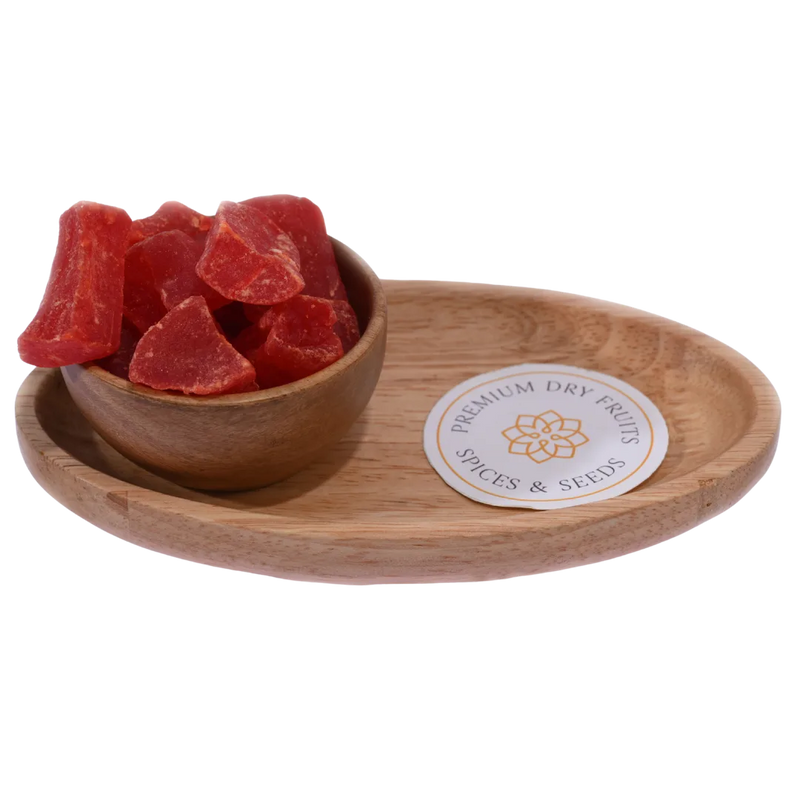 Dried papaya cubes spilling slightly from a wooden bowl, with a soft-focus background.