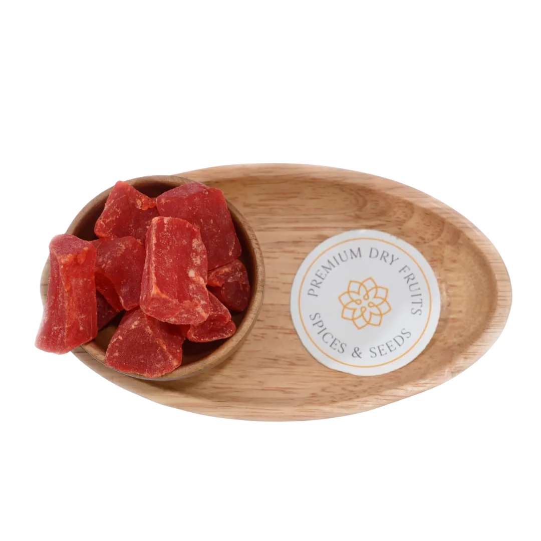 Top view of dried papaya cubes in a small wooden bowl on a rustic surface